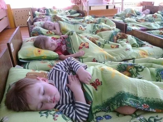 Дети в садике спят на раскладушках